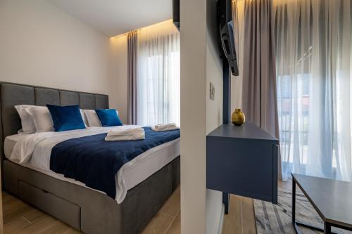 ein Schlafzimmer mit einem Bett mit blauen Laken und einem Tisch in der Unterkunft Amalia in Donji Morinj
