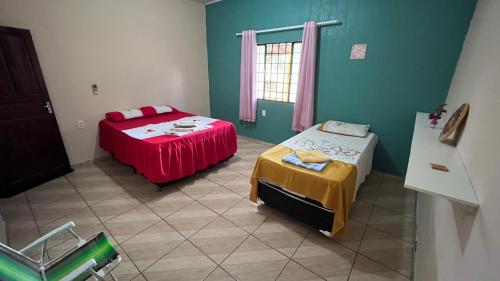 a room with two beds and a table in it at Casa Lari Hostel in Vila Tepequém