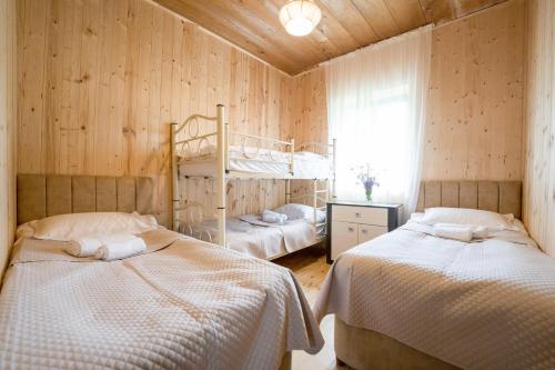 two beds in a room with wooden walls at Koruld Ushguli in Chvibiani
