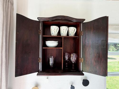 a cabinet with bowls and vases on it at Nøddehaven in Eg