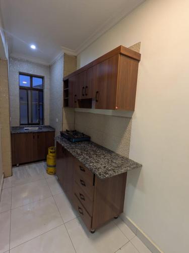 a kitchen with wooden cabinets and a counter top at Star real in Kigali