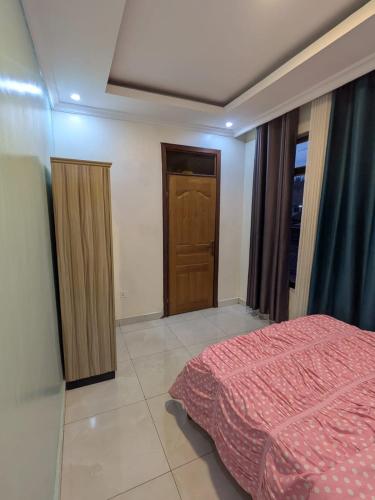 a bedroom with a bed and a wooden door at Star real in Kigali