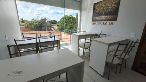 a room with tables and chairs and a large window at Hotel Lara - Simolândia in Alvorada do Norte 