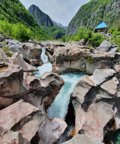 a pool of blue water in a rocky canyon at Guest House Avdi Kola in Gagu
