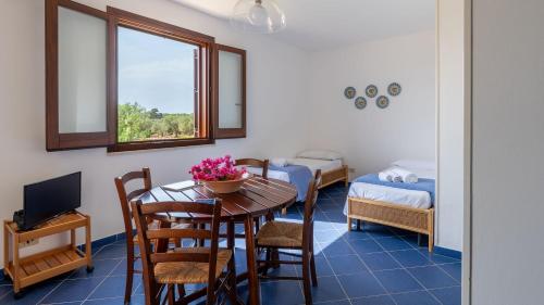 a room with a table and chairs and a bedroom at Le Casette a Favignana in Favignana