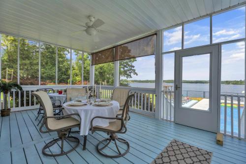 a porch with a table and chairs on it at Lakefront Getaway with Dock, Pool, Sunset Games in Greenwood