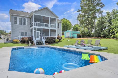 a house with a swimming pool in front of a house at Lakefront Getaway with Dock, Pool, Sunset Games in Greenwood