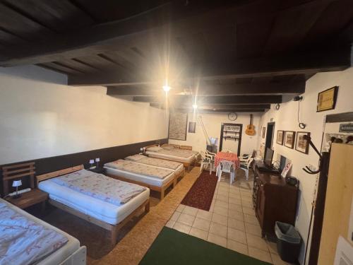 a room with four beds and a table and chairs at Görbeút Vendégház in Vigántpetend