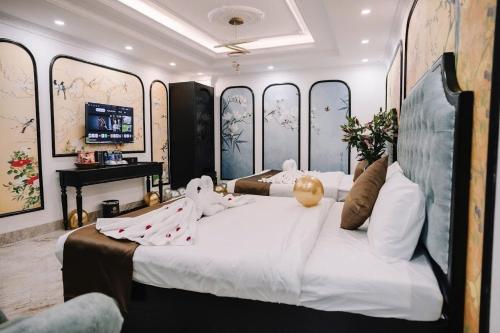 a bedroom with a large bed with decorations on it at Crown Luxury Hotel in Hanoi