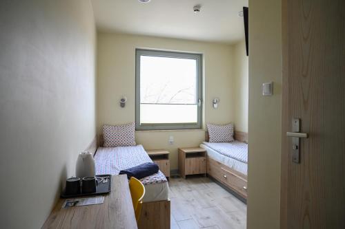 a small room with two beds and a window at Dom Żeglarza in Puck