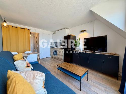 a living room with a blue couch and a tv at GC - Le Panorama - Front de Mer in Wissant