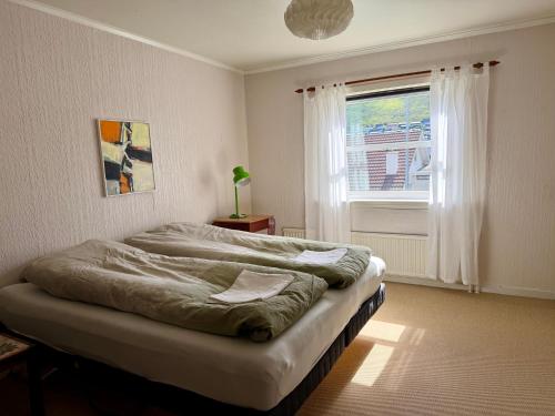 a bedroom with a large bed with a window at VILLA ORANGE - Spacious piano home in Klaksvik in Klaksvík