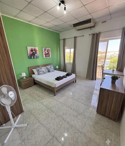a bedroom with a bed in a green wall at Victoria Centre 2BR - Opposite Bus Terminal in Victoria
