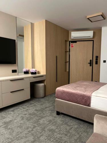 a hotel room with a bed and a television at No 11 Residence in Krynica Morska