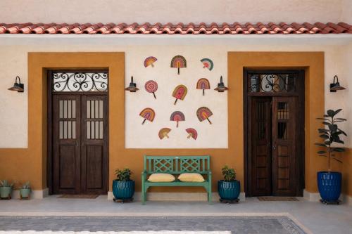 a building with a bench in front of a wall with umbrellas at Casa Feregrino Hotel Boutique in Cuatrociénegas de Carranza