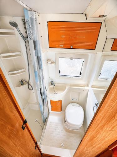 a small bathroom in an rv with a toilet and a sink at CamperTenerife in Callao Salvaje