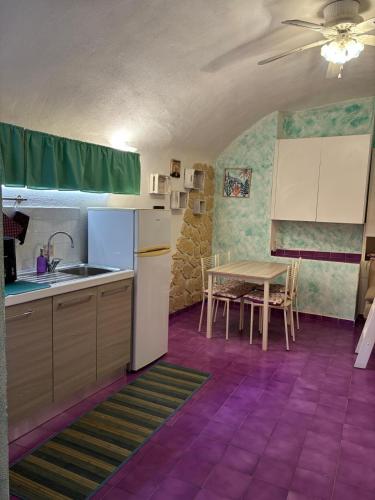 a kitchen with a table and a white refrigerator at Il tuo rifugio all' Argentario in Porto Santo Stefano