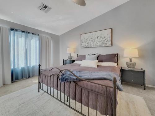 a bedroom with a large bed and two windows at 153rd Surprise in Surprise