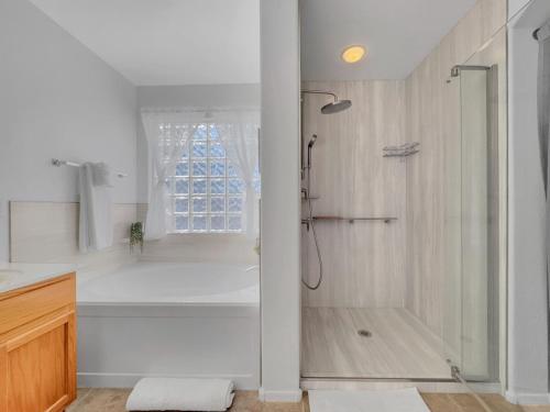 a white bathroom with a shower and a tub at 153rd Surprise in Surprise