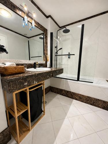 a bathroom with a sink and a tub and a mirror at Atlantic Ocean View Apartment in Funchal