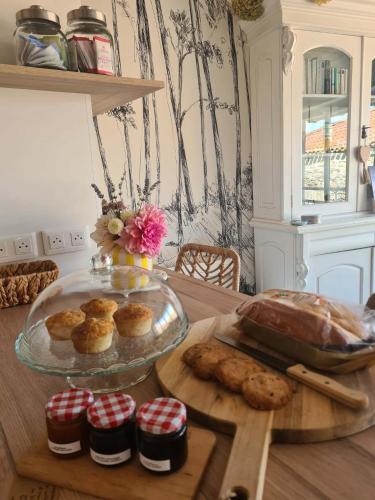 a table with a plate of pastries and cookies on it at Le Citrus - Séjour cosy en plein centre historique in Montaigu-Vendée