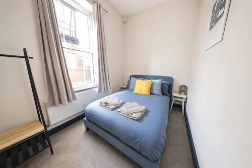 a bedroom with a blue bed and a window at Amazing City Centre Apartment in Derby