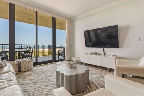 a living room with a large television and a couch at Luxury GulfFront Penthouse with Resort Amenities in Dauphin Island