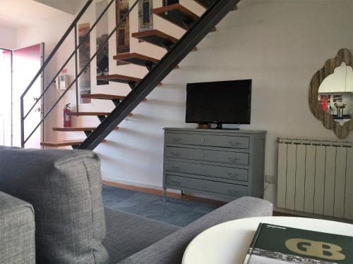 a living room with a television and a staircase at Casas do Teatro in Porto