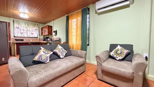 a living room with a couch and two chairs at Casa Pentagonia in Puerto Jiménez