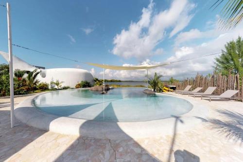 a swimming pool in a resort with chairs at Shark Studio Retreat at Swan Villas - Gold Standard Certified in Maya Beach