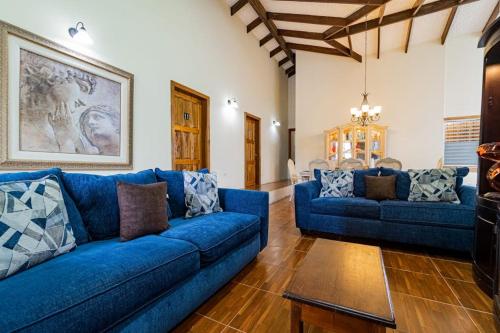 a living room with two blue couches and a table at Campo Verde House in San Ignacio