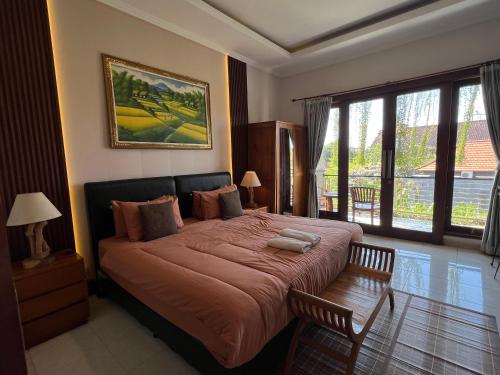 a bedroom with a large bed and a window at Surya Guest House Sanur in Sanur