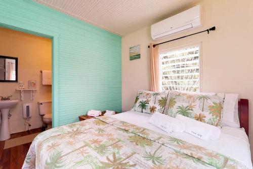a bedroom with a bed and a window at DV #2 at DV Cabanas -Gold Standard Certified in Caye Caulker