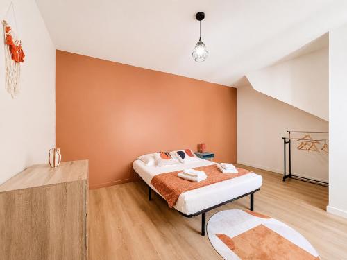 a bedroom with a bed with an orange wall at 8B - Le Cosy in Saint-Rambert-dʼAlbon