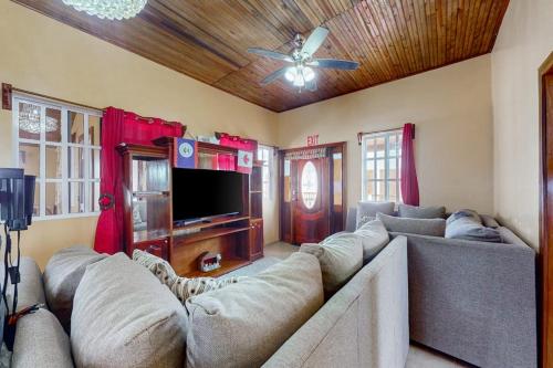 a living room with a large couch and a flat screen tv at Spartan Unit 11 in Caye Caulker