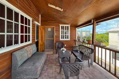 a porch with chairs and a table on a balcony at Spartan Unit 11 in Caye Caulker