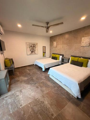 two beds in a large room with tiles at Hotel Boutique Casa Zafra in Campeche
