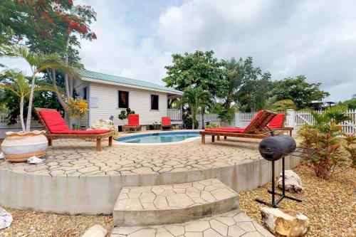 a backyard with a pool and two chairs and a house at Starfish Cabana at Latitude Adjustment -Gold Standard Certified in Hopkins