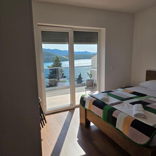 a bedroom with a bed and a view of the water at Hygge-Kuca in Neum
