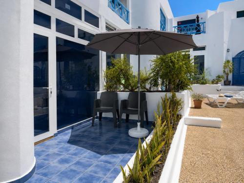 a patio with a table and an umbrella at Vanessa Puerto del Carmen in Tías