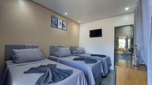 a bedroom with three beds with towels on them at Suítes Rufino in Lençóis