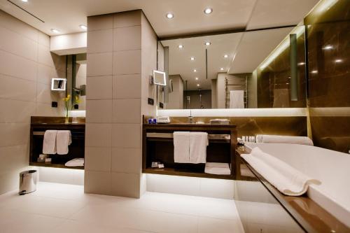 a bathroom with a tub and a large mirror at Crowne Plaza Belgrade by IHG in Belgrade
