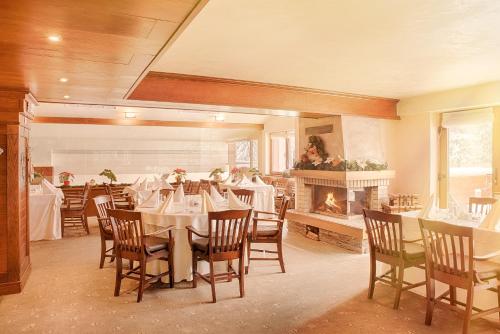 a dining room with tables and chairs and a fireplace at Hotel Yastrebets Wellness & Spa in Borovets