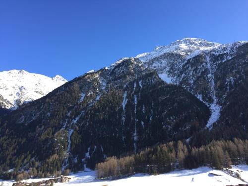 a mountain range with trees and snow on it at Haus Saskia in Sölden