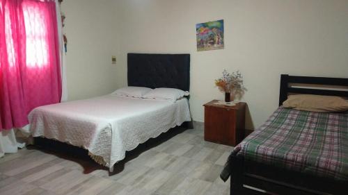 a bedroom with two beds and a night stand with a bed sidx sidx sidx sidx at Casa Las Pencas in Maimará