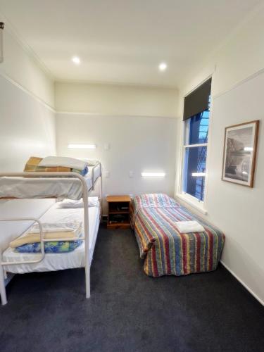 a bedroom with two bunk beds and a window at Leviathan Hotel in Dunedin