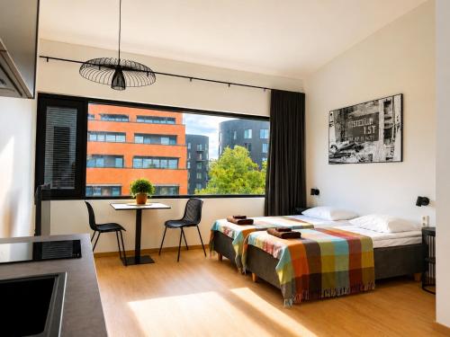 a bedroom with a bed and a table and a window at Filosoofi Suites in Tartu