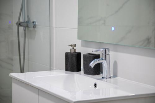a white bathroom with a sink and a mirror at Achadinha Sunset House - São Miguel, Açores in Achadinha