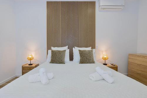 a bedroom with a white bed with two white towels on it at Achadinha Sunset House - São Miguel, Açores in Achadinha