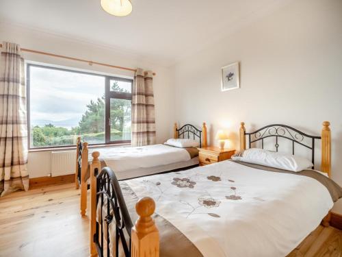 two beds in a bedroom with a large window at 4 Bed in Inch oc-ii11636 in Caheracruttera